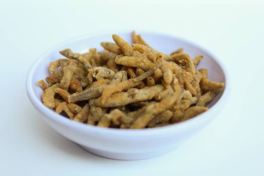 Teri çıtır çıtır, beyaz yem ya da bebek ançüez balığı ya da Endonezya 'da un ile kızartılmış teri nasi. Küçük beyaz bir kasede. Beyaz arkaplanda izole.