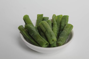 Yardlong bean cuts to shorter pieces. Steamed, placed in as small white plate. Isolated on white background. clipart