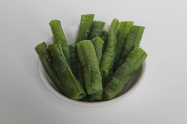 Uzun fasulye kesikleri daha kısa parçalara. Buğulanmış, küçük beyaz bir tabağa konmuş. Beyaz arkaplanda izole.