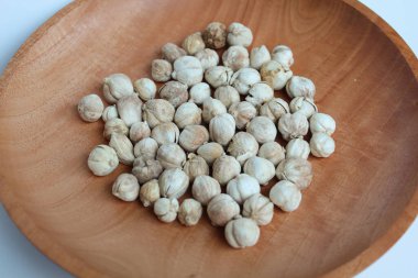 Dried cardamom fruit and seeds on wooden plate clipart