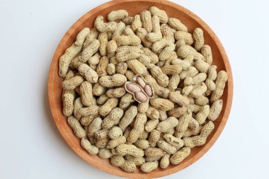 Ahşap bir arka planda fırınlanmış yer fıstığı, yer fıstığı, yer fıstığı, maymun fındığı ya da Arachis hipogaea. Düz ya da üst görünüm. Atıştırmalık olarak hazır.