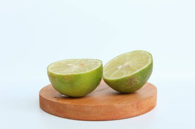 Yeşil kireç, ahşap zeminde, beyaz arka planda izole edilmiş.