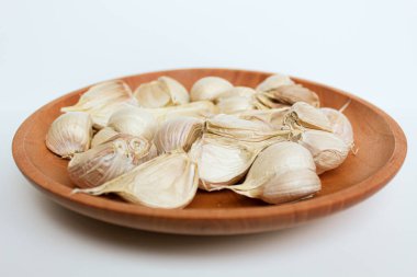 Sarımsak karanfili veya ahşap tabakta ampul, beyaz arka planda izole edilmiş.