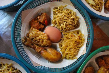 Nasi Berkat, Endonezya 'dan geleneksel gıda paketi. Cava kabilesindeki dini törenden sonra verilen yemek. Pirinç, kızarmış tavuk, haşlanmış yumurta, erişte, kızarmış tempeh ve sambal goreng. Düz ya da üst görünüm