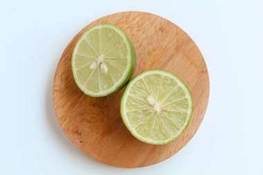 Yeşil kireç, ahşap zeminde, beyaz arka planda izole edilmiş. Düz ya da üst görünüm