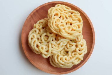 Kerupuk Mie Kuning ya da Sarı Erişte Krakeri, Endonezya 'dan gelen yemek çeşnisi. Tahta tabakta. Beyaz arka planda izole edilmiş. Düz ya da üst görünüm