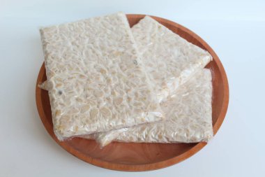 Tempeh ya da tempe, işlenmiş soya ürünü, ahşap arka planda. Beyaz arkaplanda izole