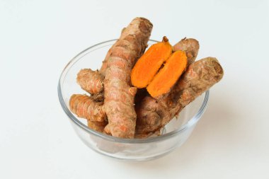 Turmeric or Curcuma longa rhizome in transparent bowl, isolated in white background clipart