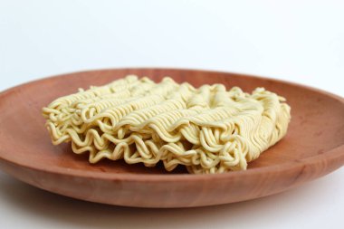 Pişmeden önce kare hazır erişte, ahşap zemin üzerinde, beyaz arka planda izole edilmiş.