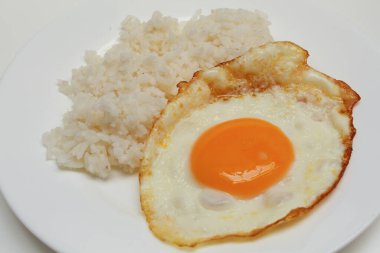 Güneşte pişmiş yumurta ve beyaz tabakta pilav. Beyaz arkaplanda izole