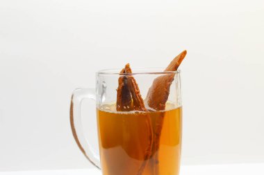 A cup of Temulawak drink. Temulawak or Curcuma zanthorrhiza or Javanese turmeric. In a transparent glass, isolated on white background clipart