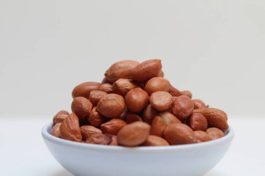 Yer fıstığı, yer fıstığı, yer fıstığı ya da maymun fıstığı. İnce kırmızı derili soyulmuş fıstık. Beyaz arkaplanda izole