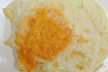 İyi pişmiş yumurta. Yumurta ters çevrildi ve yumurta sarısı sert pişirildi. Kızarmış tavuk yumurtası. Beyaz bir tabakta