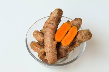 Turmeric or Curcuma longa rhizome in transparent bowl, isolated in white background clipart