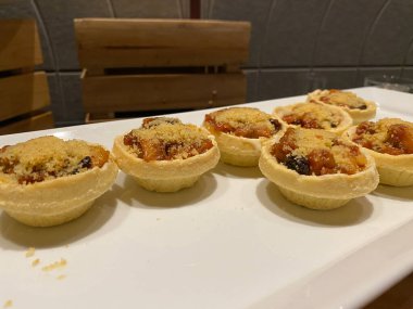 Beyaz bir tabakta muz parçacıklarıyla dolu mini turta kabuğu.