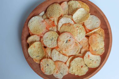 Opak, Cassava 'dan yapılmış, düz yuvarlak bir şekle bürünmüş. Endonezya 'dan atıştırmalık. Tahta bir tabakta, beyaz arka planda izole, düz ya da üst görünümde