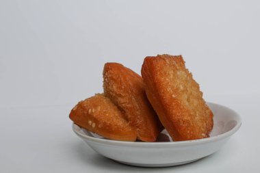 Odading veya Bolang-Baling veya Yastık Keki, Endonezya 'dan susam tohumlu tatlı ekmek. Arka planda izole edilmiş küçük bir tabakta