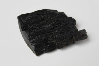 Tahtadan bir parça kömür, beyaz arka planda izole edilmiş.