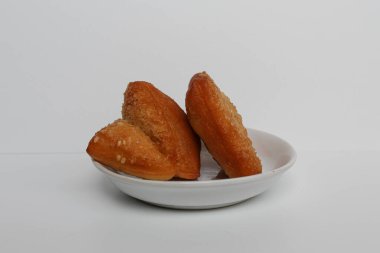 Odading veya Bolang-Baling veya Yastık Keki, Endonezya 'dan susam tohumlu tatlı ekmek. Arka planda izole edilmiş küçük bir tabakta