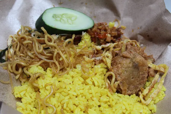 Nasi kuning veya sarı renkli pirinç, Endonezya 'dan geleneksel bir yemektir, erişte, salatalık dilimi, tempeh, sambal ve perkedel ile servis edilir.