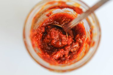 Sambal, Endonezya 'da kullanılan bir acı biber sosudur. Şeffaf cam bir kavanozda. Beyaz arkaplan, üst görünüm veya düz yatış üzerinde izole