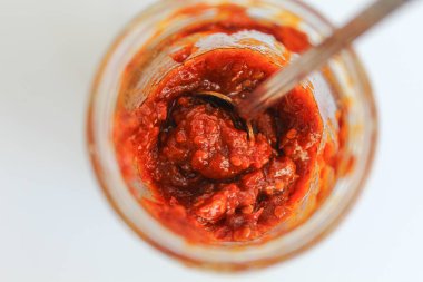 Sambal, Endonezya 'da kullanılan bir acı biber sosudur. Şeffaf cam bir kavanozda. Beyaz arkaplan, üst görünüm veya düz yatış üzerinde izole
