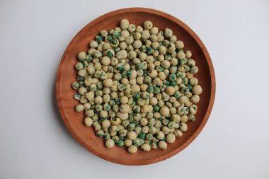 Kızarmış yeşil bezelye, hamur unu, düz ya da üst görünüm, tahta tabakta, beyaz arka planda izole.