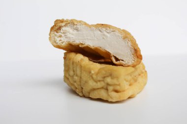 Kızarmış sarı tofu dilimlenmiş, beyaz arka planda izole edilmiş.