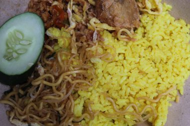 Nasi kuning veya sarı renkli pirinç, Endonezya 'dan geleneksel bir yemektir, erişte, salatalık dilimi, tempeh, sambal ve perkedel ile servis edilir.