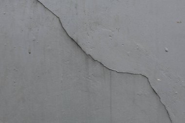 Black cracks on the grey colored wall. Cracked wall clipart