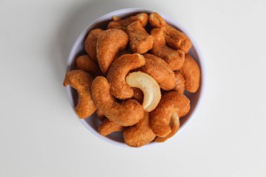 Küçük beyaz bir kasede kaju fıstığı. beyaz arkaplanda izole edilmiş, düz ya da üst görünümde