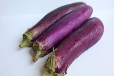 Three long purple eggplants isolated on white background clipart