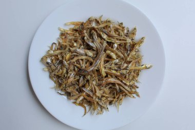 Kurutulmuş ançüez balığı, pişmemiş, beyaz kaplamalı, beyaz arka planda. Tuzla korunmuş. Düz ya da üst görünüm