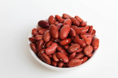 Kırmızı fasulye, bir kasede, beyaz arka planda izole edilmiş.