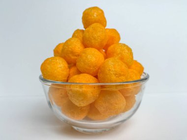 Cheese balls crackers in a transparent bowl, isolated on white background clipart