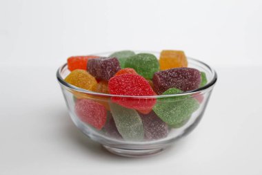 Renkli şekerleme ya da şeffaf kâse içinde meyveli jöle, beyaz arka planda izole.