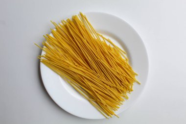 Mie lidi, traditional snack from Indonesia. Noodle-like texture, fried and salted. On white plate, isolated on white background, top view or flat lay clipart