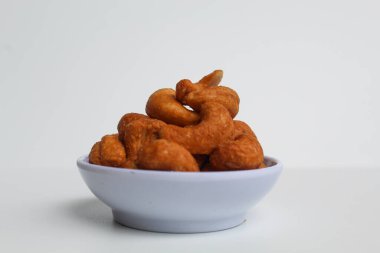 Küçük beyaz bir kasede kaju fıstığı. beyaz arkaplanda izole edilmiş, kenar görünüm