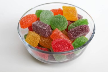 Renkli şekerleme ya da şeffaf kâse içinde meyveli jöle, beyaz arka planda izole.
