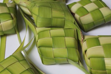 Ketupat ambalajı, pişmeden önce örülmüş taze hindistan cevizi yaprakları. Beyaz arkaplanda izole