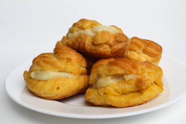 Kremalı pasta, beyaz tabakta, beyaz arka planda izole edilmiş.