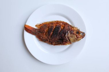 Beyaz bir tabakta kızarmış gurami balığı, beyaz arka planda izole edilmiş, düz ya da üst görünümde