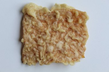 Bir parça keripik tempo ya da tempeh kraker, kare şeklinde. İnce dilimler, un hamuruyla kızartılmış tempeh. Beyaz arkaplan, düz yatay veya üst görünümde izole edilmiş