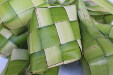 Ketupat ambalajı, pişmeden önce örülmüş taze hindistan cevizi yaprakları. Beyaz arkaplanda izole