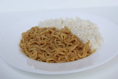 Bir tabak kızarmış şehriye ve beyaz tabakta beyaz arka planda izole edilmiş beyaz pirinç.