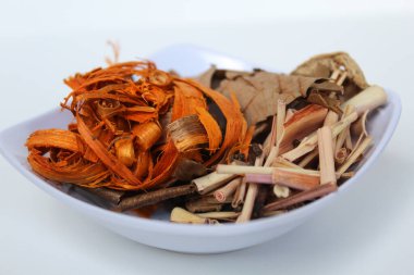 Wedang Uwuh, or Javanese herbal drink, isolated on white background. Ingredients before brewed of Indian redwood, dried ginger, lemongrass and cardamom clipart