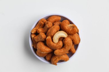 Küçük beyaz bir kasede kaju fıstığı. beyaz arkaplanda izole edilmiş, düz ya da üst görünümde