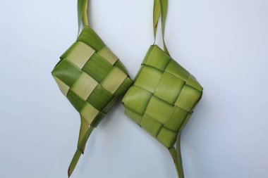 Ketupat ambalajı, pişmeden önce örülmüş taze hindistan cevizi yaprakları. Beyaz arkaplanda izole