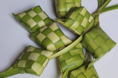 Ketupat ambalajı, pişmeden önce örülmüş taze hindistan cevizi yaprakları. Beyaz arkaplanda izole