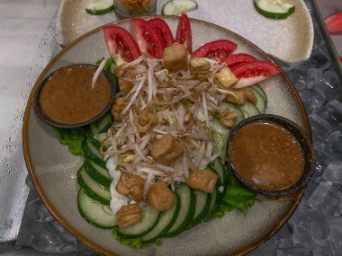 Gado-gado Endonezya 'dan geleneksel bir salatadır. Pişmiş sebzeler, tofu dilimleri, mung fasulyesi filizi ve fıstık sosundan yapılır.